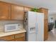 Kitchen featuring light countertops, white appliances, and wood-tone cabinets at 2866 Rosecommons Dr, Hampton, GA 30228