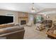 Spacious living room featuring a stone fireplace, ceiling fan, and ample seating, perfect for gatherings at 2866 Rosecommons Dr, Hampton, GA 30228