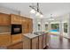Kitchen with wooden cabinets and island with cooktop, opens to a view of the pool outside at 11 Chad Ct, Mcdonough, GA 30253