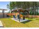 Backyard featuring a gazebo with seating, fire pit, putting green, and a hot tub at 845 Graeme Dr, Mcdonough, GA 30252