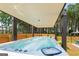 Covered hot tub and seating area in a private backyard with a privacy fence and putting green at 845 Graeme Dr, Mcdonough, GA 30252