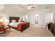 Spacious main bedroom with high ceilings, fan, a large bed, rocking chair and ensuite bathroom at 845 Graeme Dr, Mcdonough, GA 30252