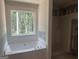 Unfinished bathroom showcasing a large tub and window at 5565 Hwy 155, Stockbridge, GA 30281