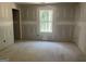Unfinished bedroom with a large window and access to a hallway at 5565 Hwy 155, Stockbridge, GA 30281
