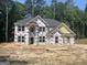 Two story home's exterior under construction showing window placement and framing against a wooded backdrop at 5565 Hwy 155, Stockbridge, GA 30281