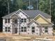 New two-story home with yellow siding, a grey roof, and large windows in a wooded lot at 5565 Hwy 155, Stockbridge, GA 30281