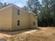 Two-story home exterior showing siding, several windows, and natural surroundings under a sunny sky at 5565 Hwy 155, Stockbridge, GA 30281