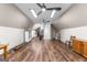 This large attic features wood flooring, two ceiling fans, and white walls with lighting at 152 Bear Creek Rd, Moreland, GA 30259