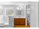 Bright bathroom featuring a wooden vanity, tiled tub, and natural light from a glass block window at 152 Bear Creek Rd, Moreland, GA 30259