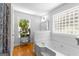 Inviting bathroom featuring a large tub, natural lighting and a plant shelf to give the space some color at 152 Bear Creek Rd, Moreland, GA 30259
