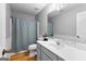 Cozy bathroom with white beadboard, wood floors, a shower/tub and modern fixtures, and bright lighting at 152 Bear Creek Rd, Moreland, GA 30259