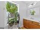Bright bathroom featuring a shelf with plants, modern lighting, and a sleek wooden vanity at 152 Bear Creek Rd, Moreland, GA 30259