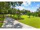 Long paved driveway leading to a beautiful house is surrounded by lush greenery and mature trees at 152 Bear Creek Rd, Moreland, GA 30259
