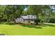 A well-manicured lawn complements this charming gray home, nestled amongst mature shade trees at 152 Bear Creek Rd, Moreland, GA 30259