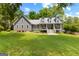 Charming gray home features a meticulously manicured lawn, colorful flowerbeds, and dormer windows at 152 Bear Creek Rd, Moreland, GA 30259