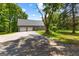 Large garage with ample parking space and a well-maintained driveway, surrounded by mature trees at 152 Bear Creek Rd, Moreland, GA 30259