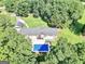 Aerial view of a house and property with an in-ground pool surrounded by lush greenery and mature trees at 234 Crumbley Rd, Mcdonough, GA 30252