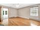 Sunlit bedroom with hardwood floors, neutral paint, a ceiling fan, and backyard view at 234 Crumbley Rd, Mcdonough, GA 30252