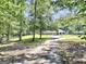 A long driveway leading to a classic home with a covered parking area surrounded by lush trees at 234 Crumbley Rd, Mcdonough, GA 30252