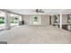 Light-filled living space featuring neutral carpet, multiple windows and ceiling fan at 234 Crumbley Rd, Mcdonough, GA 30252