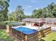 In-ground pool with a concrete patio and brick house with a covered patio in the background, fenced-in yard at 234 Crumbley Rd, Mcdonough, GA 30252