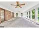 Spacious sun room with ample natural light, brick accent wall and neutral carpeting at 234 Crumbley Rd, Mcdonough, GA 30252