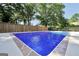 Beautiful blue rectangular pool surrounded by a concrete perimeter and a tall fence at 234 Crumbley Rd, Mcdonough, GA 30252