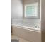 Bright and spacious bathroom featuring a relaxing, tiled soaking tub at 1032 Shumard Ln, Mcdonough, GA 30252