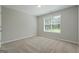 Bright bedroom with a neutral color scheme, plush carpet, and a window at 1032 Shumard Ln, Mcdonough, GA 30252
