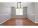 Dining room with neutral colors, hardwood floors, modern chandelier, and a large window at 1032 Shumard Ln, Mcdonough, GA 30252
