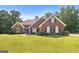 Charming single-story red brick home features manicured lawn and lush landscaping at 1032 Shumard Ln, Mcdonough, GA 30252