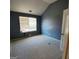 Cozy bedroom featuring soft carpet, a window for natural light, and blue painted walls at 7471 Garnet Dr, Jonesboro, GA 30236