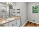 Bathroom with white cabinets, a large mirror, and a window providing ample natural light at 1000 Coan Dr, Locust Grove, GA 30248