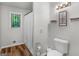 Bright bathroom featuring wood-look flooring, modern fixtures, and a window bringing in natural light at 1000 Coan Dr, Locust Grove, GA 30248