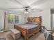 Comfortable bedroom featuring a wooden bed frame, ceiling fan, and large window at 1000 Coan Dr, Locust Grove, GA 30248