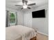 Bedroom featuring a bed, mounted tv, window with curtains, and white closet doors at 1000 Coan Dr, Locust Grove, GA 30248