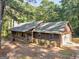 A view of the house that shows a wrap-around porch and an attached garage at 1000 Coan Dr, Locust Grove, GA 30248