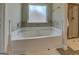 Elegant bathtub with tile surround and glass-enclosed shower create a spa-like retreat at 116 Sophie Cir, Locust Grove, GA 30248