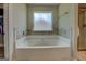 Bright bathroom showcases a soaking tub with tile surround and a glass-enclosed shower at 116 Sophie Cir, Locust Grove, GA 30248