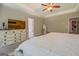 Comfortable main bedroom with ceiling fan, white dresser, and an open ensuite bathroom at 116 Sophie Cir, Locust Grove, GA 30248