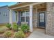 Inviting front porch with brick accents, seating, and well-maintained landscaping at 116 Sophie Cir, Locust Grove, GA 30248