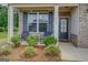Inviting front porch with brick accents, seating, and well-maintained landscaping at 116 Sophie Cir, Locust Grove, GA 30248