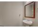 Pedestal sink and framed mirror in the powder room offer a clean and modern design at 116 Sophie Cir, Locust Grove, GA 30248