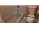 Close up of a white toilet with a blue tape strip along with a white tiled bathtub with chrome faucet at 2498 Robinhood Dr, Ellenwood, GA 30294