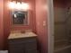 Cozy bathroom featuring a vanity with gray cabinetry, white countertops, framed mirror, and a shower-tub combination at 2498 Robinhood Dr, Ellenwood, GA 30294