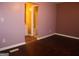 Bedroom featuring wood flooring, purple walls, and a bathroom area at 2498 Robinhood Dr, Ellenwood, GA 30294