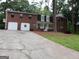 Charming two-story brick home with a well-maintained lawn and a long driveway, offering curb appeal and convenience at 2498 Robinhood Dr, Ellenwood, GA 30294