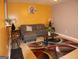 Living room featuring a gray sofa, decorative rug, stool seating, and bright yellow walls at 2498 Robinhood Dr, Ellenwood, GA 30294