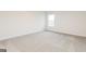 Clean bedroom showcasing plush carpeting and a window providing natural light, creating a comfortable feel at 264 Oliver Dr, Locust Grove, GA 30248