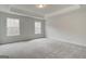 Carpeted bedroom featuring neutral paint, tray ceilings and abundant natural light at 4454 Eastbrook Pl # 57B, Snellville, GA 30039